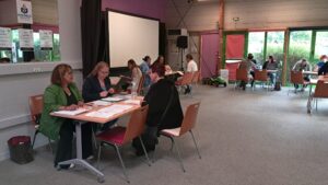 Simulation de forum de l'emploi, des stagiaires discutant autour d'une table avec des fiches métiers