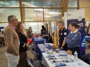 4 personnes discutent autour d'un stand avec le sourir. C'est le stand de la marine à un forum - le forum de l'emploi et de l'inclusion du COS CRPF.