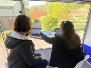 Deux personnes travaillent sur tablette près d’une fenêtre, dans un environnement lumineux donnant sur l’extérieur - Tests de personnalité et d’orientation