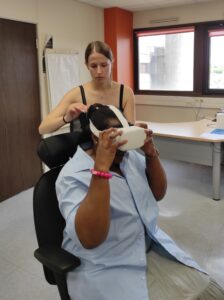 Une personne teste un casque de réalité virtuelle, accompagnée par une professionnelle lors d’un atelier - immersion art et culture