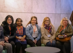 Cinq participantes assises côte à côte posent pour une photo de groupe de la formation secrétaire assistante